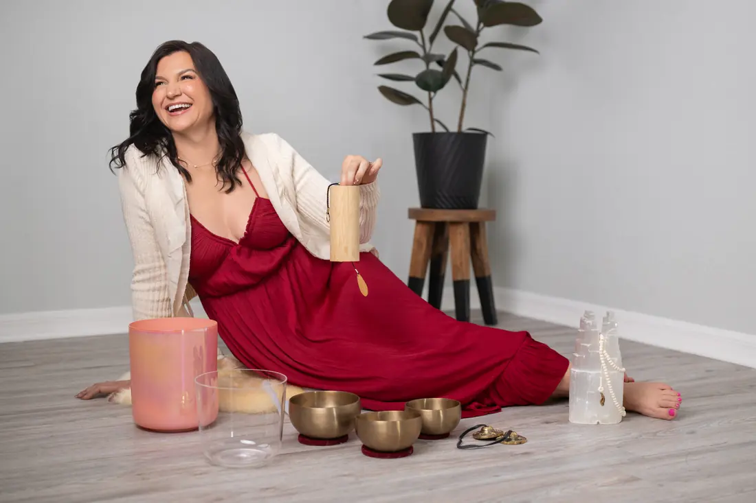 Leia seated on the floor surrounded by singing bowls during a sound healing session